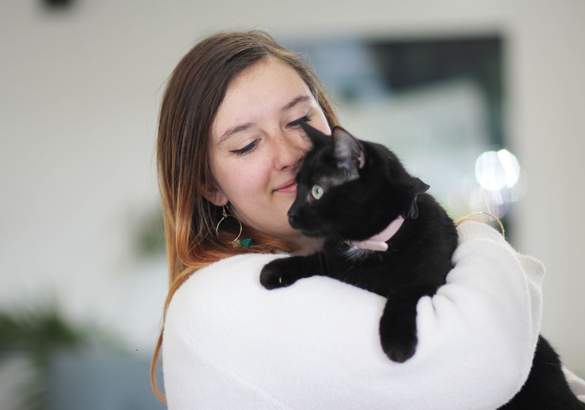 camille tenant un chat noir dans les bras