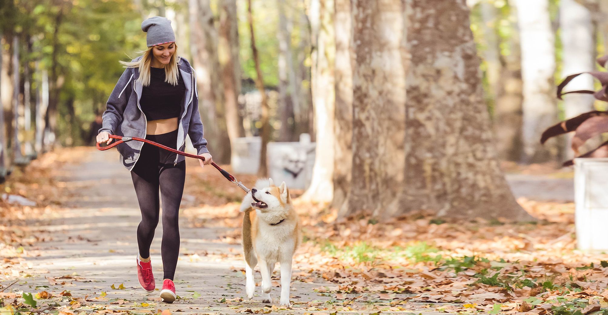 Une femme courant avec son chien en pleine nature