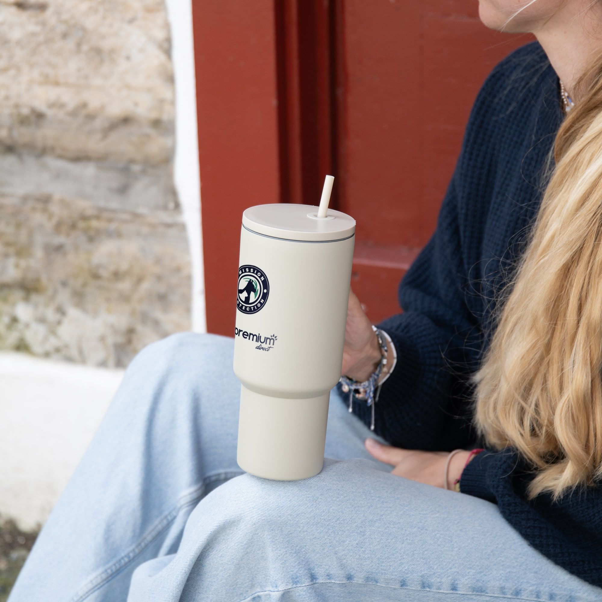 Femme blonde assise qui tient la gourde dans sa main droite