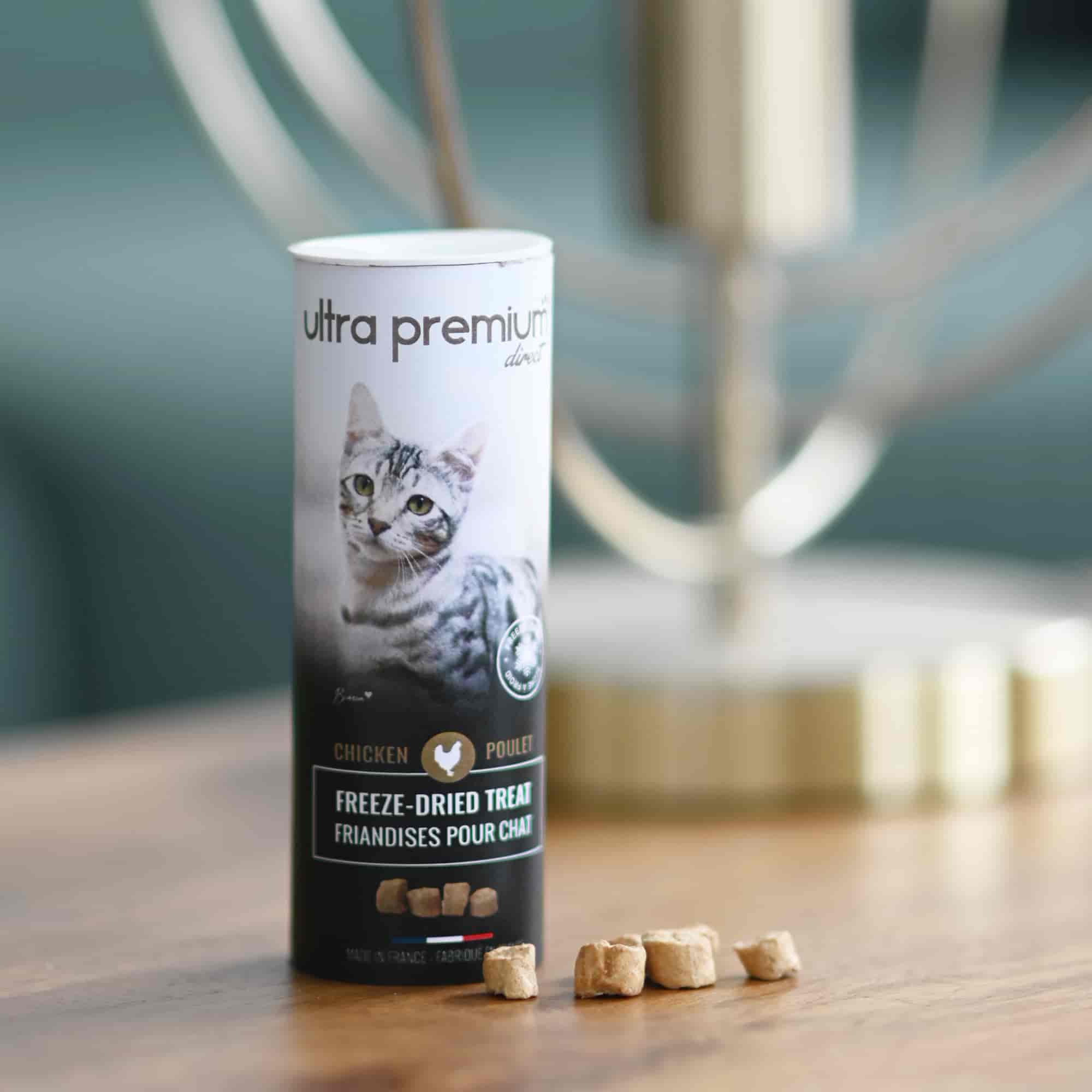 Friandises Freeze Dried Treat de poulet séché à froid pour chat, posées sur une table en bois