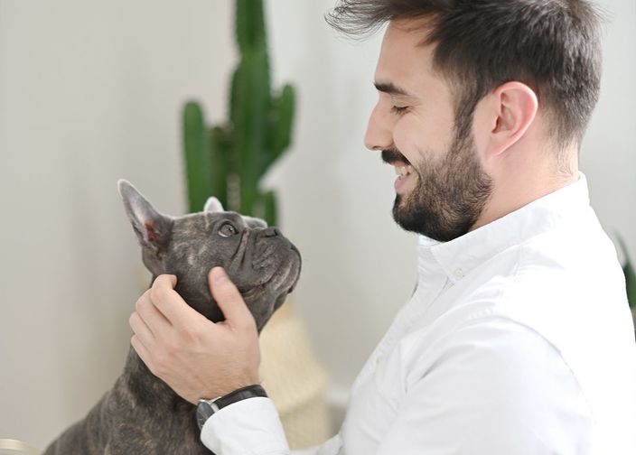 Maître caressant son bouledogue français 