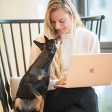Lison avec son ordinateur sur les genoux et sa chienne pixie, un pinscher nain.