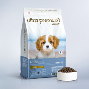 Croquettes Super Premium pour chiot de petite et moyenne taille en sac de 12 kg sur fond bleu clair