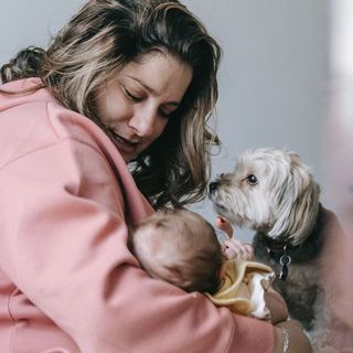 Mère tenant son bébé avec son chien à côté