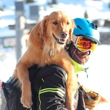 maître-chien d'avalanche avec son chien sur les épaules