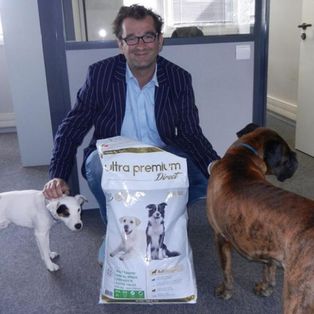 Matthieu Wincker, fondateur d'Ultra Premium Direct avec 2 chiens et un sac de croquettes